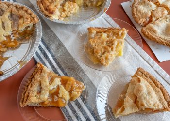 Several apple pies and slices on plate on table