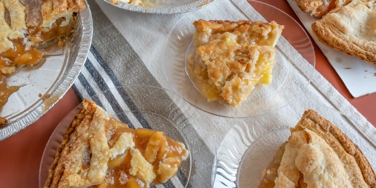 Several apple pies and slices on plate on table
