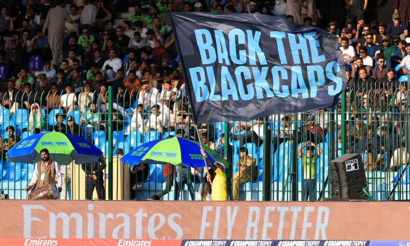 Ground staff waves a New Zealand support banner during the match. — Reuters