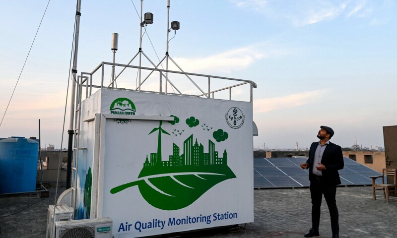  This photograph taken on February 17, 2025 shows an Anti-Smog Squad (ASS) official looking at an air quality monitoring station installed on the terrace of a university in Lahore. — AFP 