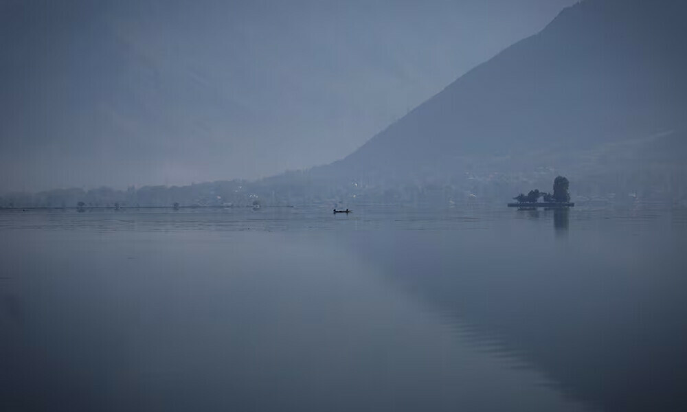  Kashmiri men row a traditional shikara boat on the waters of Dal Lake in Srinagar. Photo: Reuters 