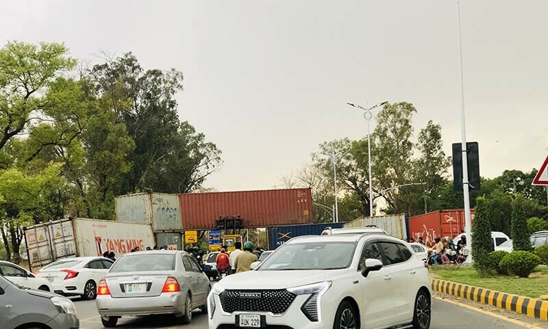 Motorists in Islamabad encounter shipping containers on their route amid the Jamaat-i-Islami’s ‘Palestine Solidarity March’ on April 20. — Umar Bacha 