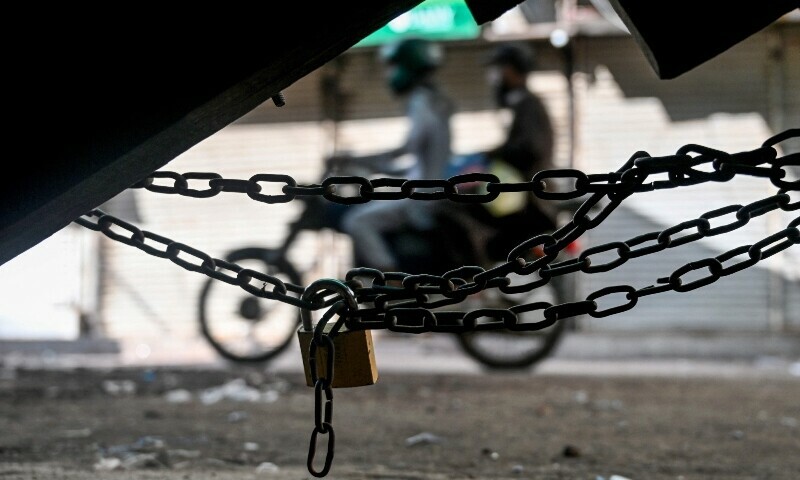 Motorcyclists move past a closed shop during a nationwide strike to show their solidarity with Palestinians, in Karachi on April 26, 2025, amid the ongoing Gaza conflict. — AFP