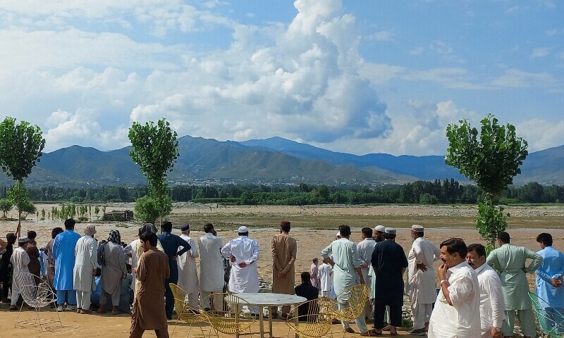 Residents gather around the Swat River, Swat, June 27. — Reuters