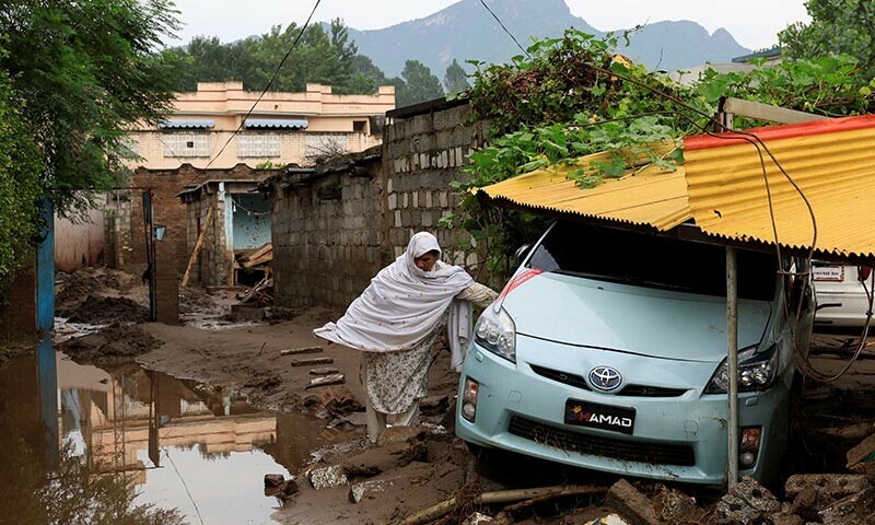 A resident walks past a vehicle following a storm that caused heavy rains and flooding, in Bayshonai Kalay, Buner district, Khyber Pakhtunkhwa province, Pakistan, August 17, 2025. — Reuters