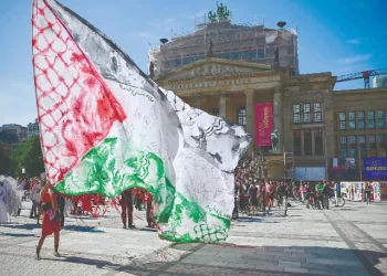 a demonstrator waves a giant palestinian flag as spectators gather for a classical concert at the gendarmenmarkt square outside the konzerthaus concert hall in berlin the concert was performed on world children s day on september 20 for the children of gaza photo afp