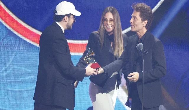 bad bunny accepts the award for best urban song for deb tirar m s fotos from presenters daisy fuentes and richard marx at the 26th annual latin grammy awards in las vegas photo reuters