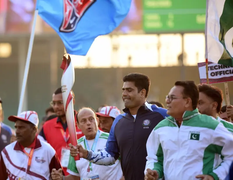 Olympic gold medallist Arshad Nadeem and hockey great Islahuddin Siddique with torch for the National Games in Karachi on Saturday. — Tahir Jamal/White Star