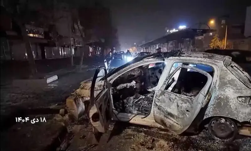 A burnt car lies on the road following unrest sparked by dire economic conditions, in a place given as Tehran. Photo: Reuters