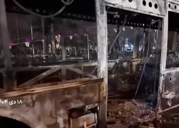 A burnt bus lies on the road following unrest sparked by dire economic conditions, in a place given as Tehran, Iran. Photo: Reuters