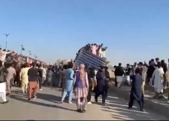People push aside containers that had been placed to block a route in Karachi. &mdash; screengrab from video via Imtiaz Ali