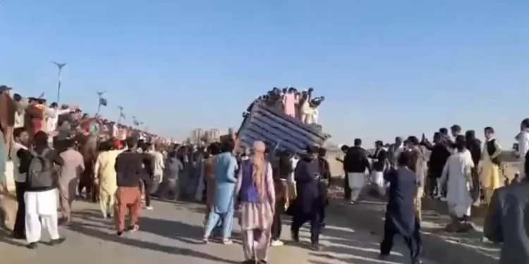 People push aside containers that had been placed to block a route in Karachi. &mdash; screengrab from video via Imtiaz Ali