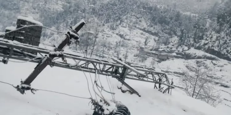 .An electricity supply pole lies on the ground after heavy snowfall in Shangla. &mdash;  Umar Bacha