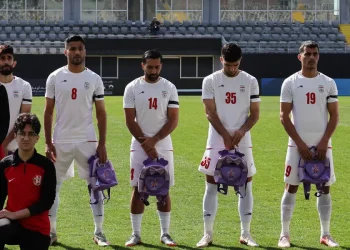 Iranian players hold schoolbags in protest over slain girls