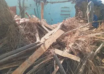A man looks at the debris of a collapsed house in Swabi. — Dawn