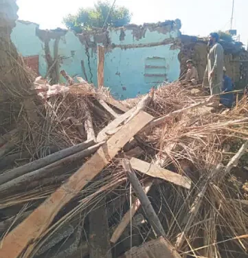 A man looks at the debris of a collapsed house in Swabi. — Dawn
